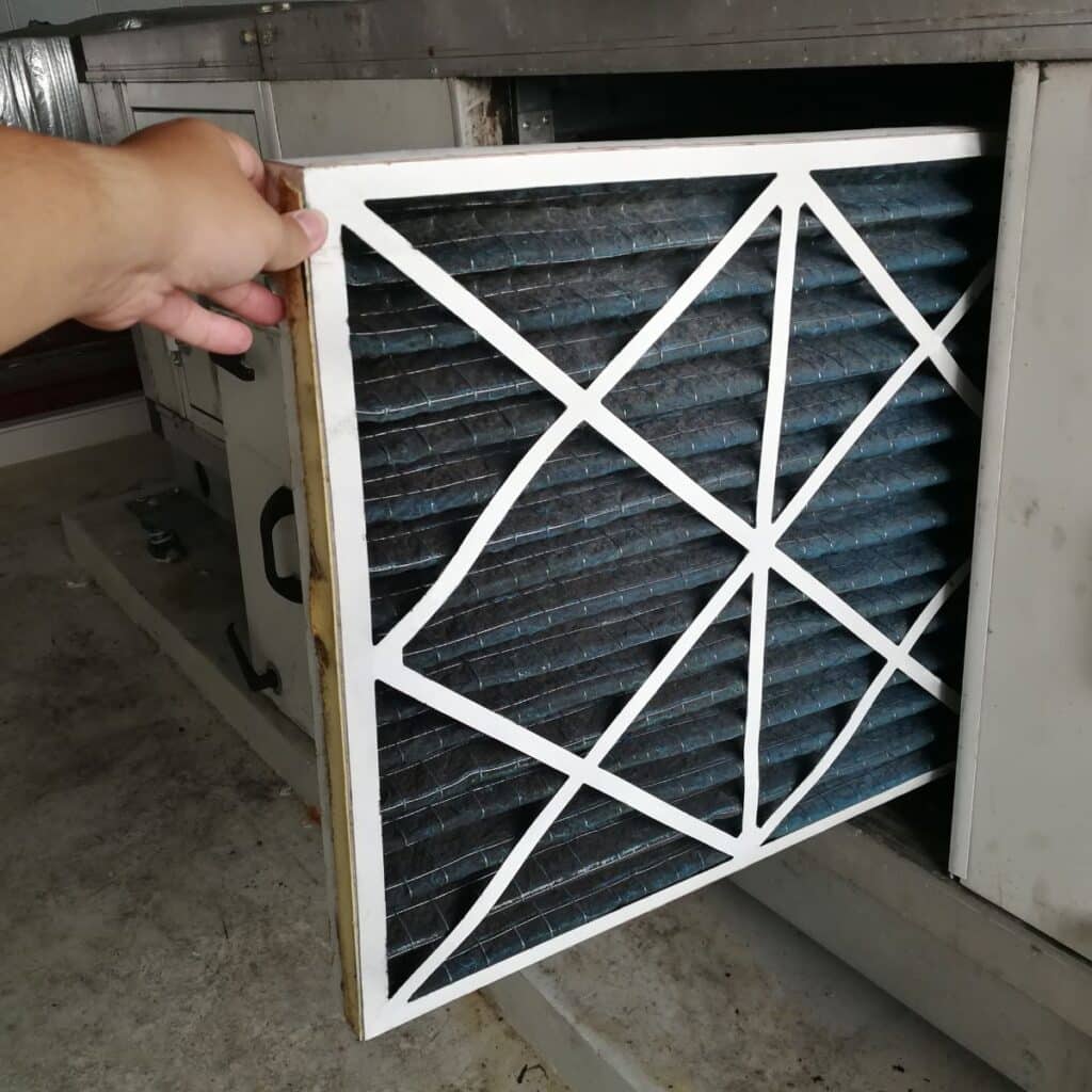 AC filter being pushed into it's spot by a technicians hand