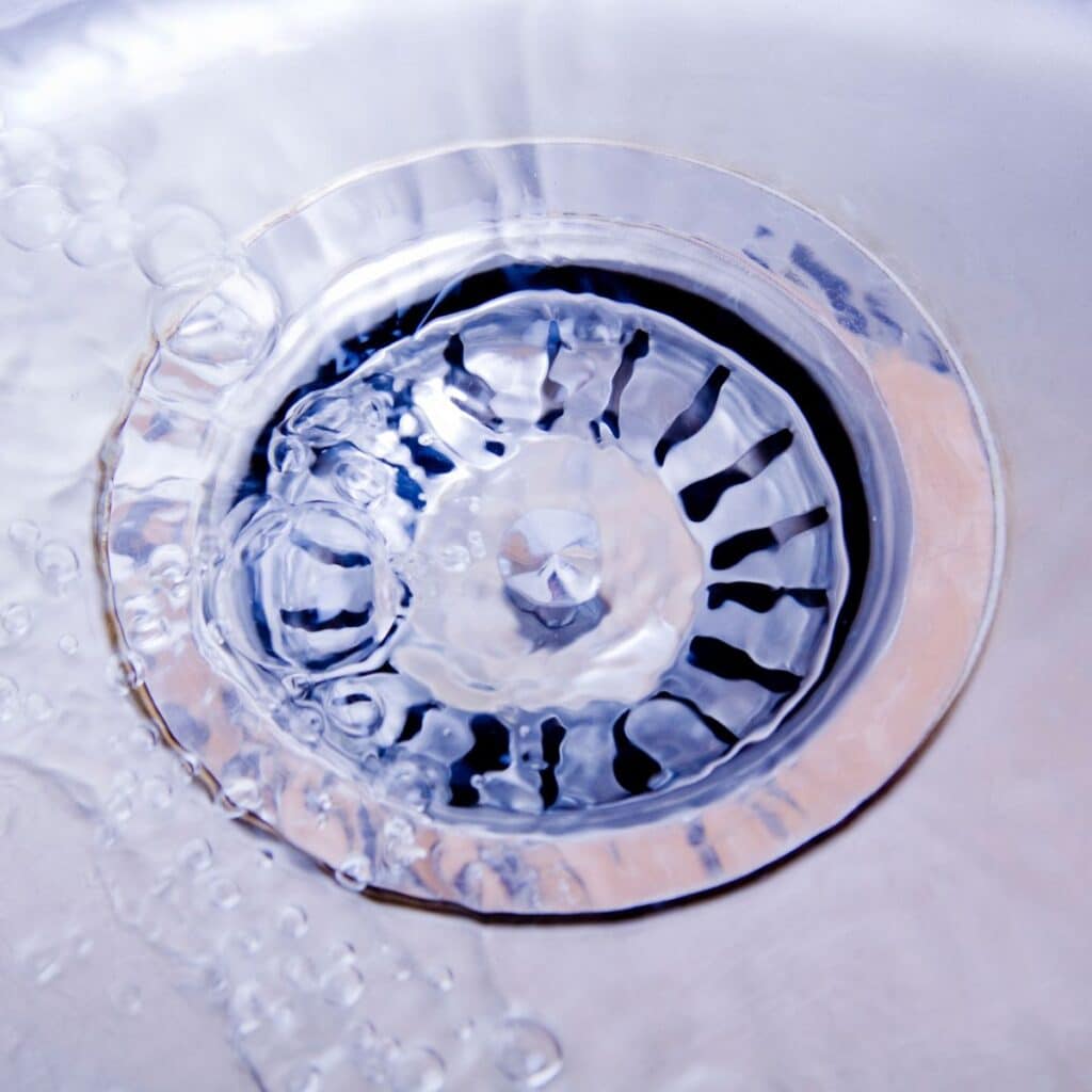 silver sink drain covered in water