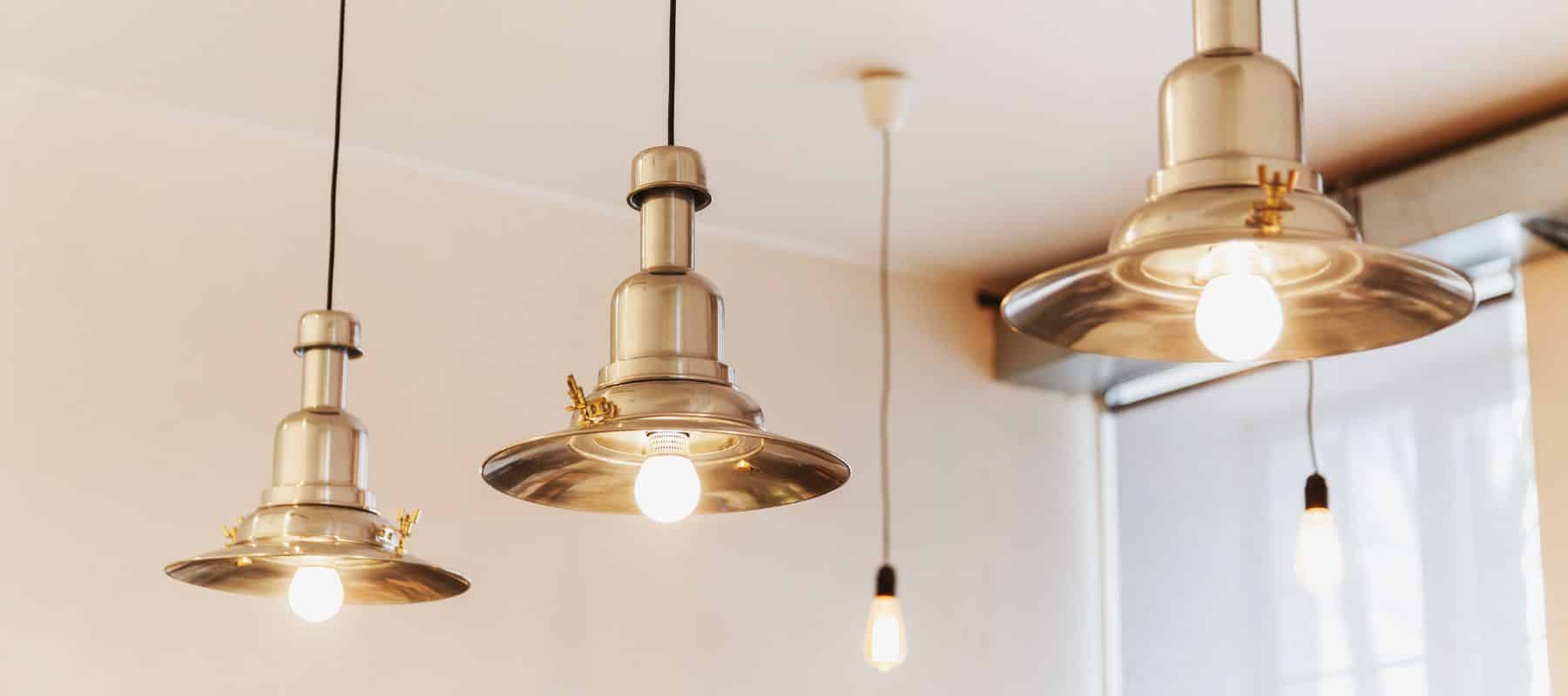 closeup of lights hanging from the ceiling showing gold plated light covers