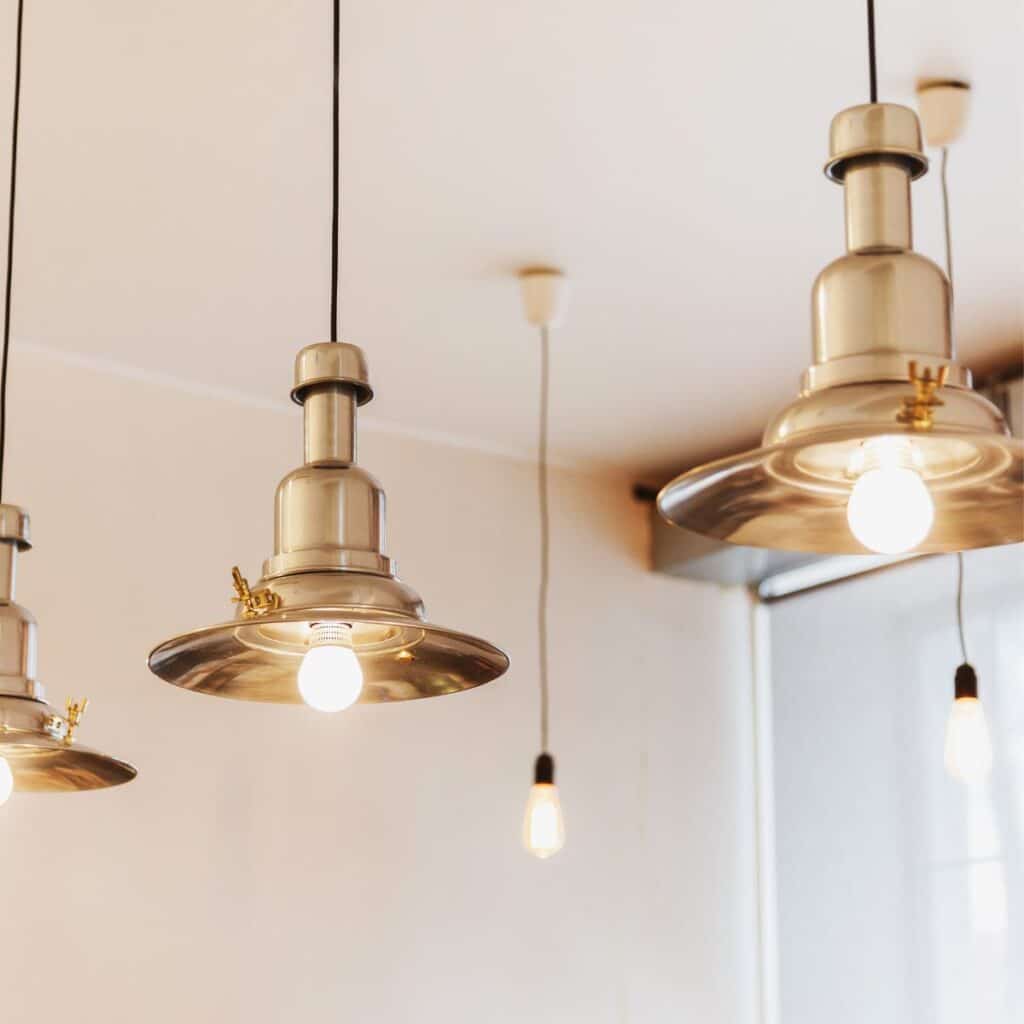 closeup of lights hanging from the ceiling showing gold plated light covers