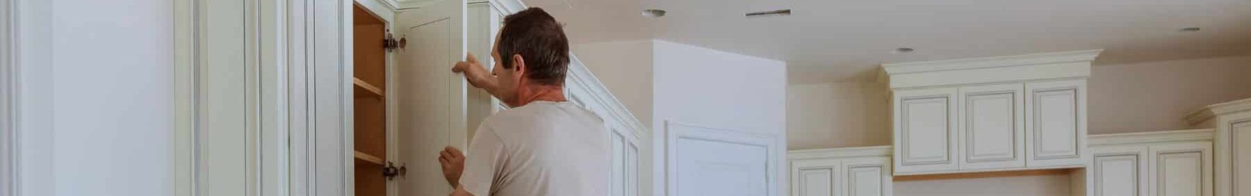 Worker replacing kitchen cabinet