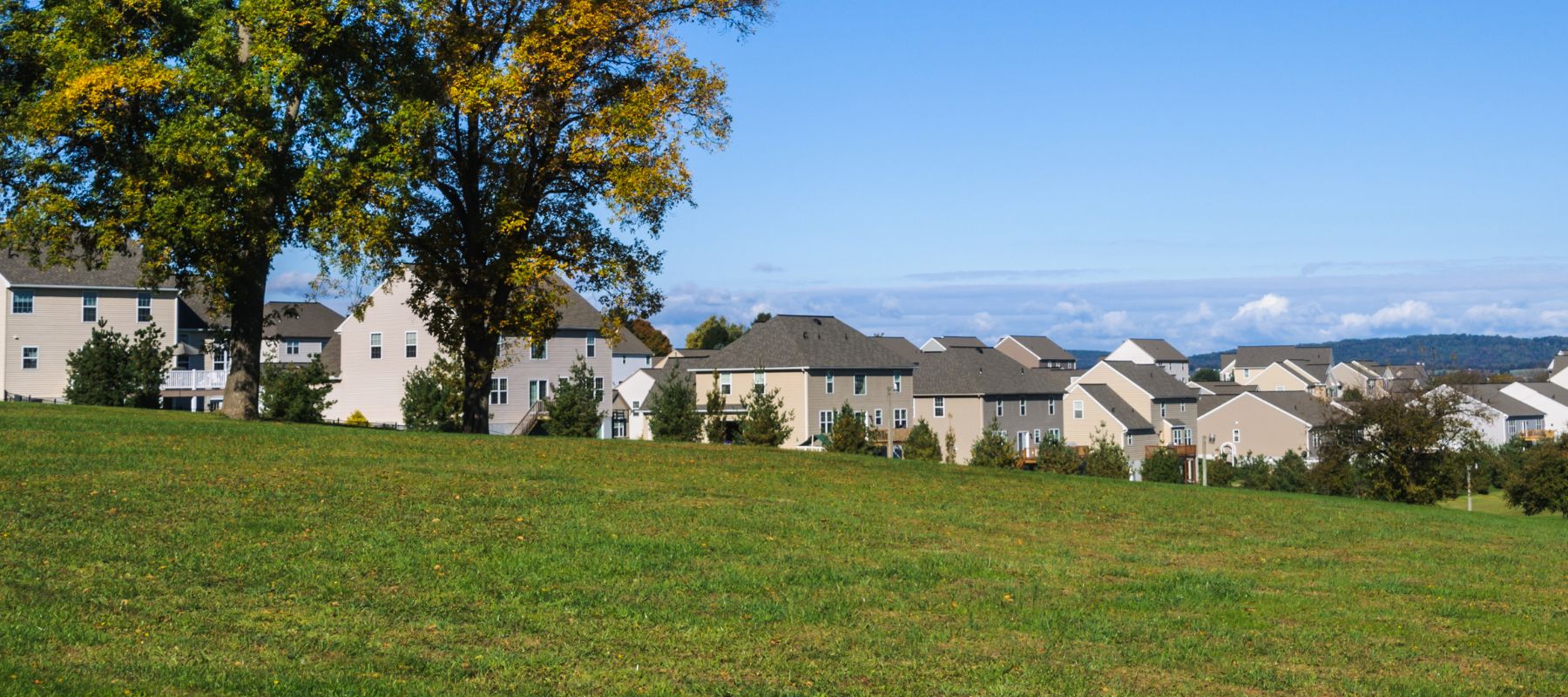 rolling hills with a neighborhood in the background