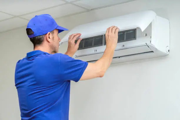 HVAC technician testing refrigerant pressures and electrical components during complex emergency cooling repair, Experienced HVAC technician measuring AC system performance with gauges and electrical tools