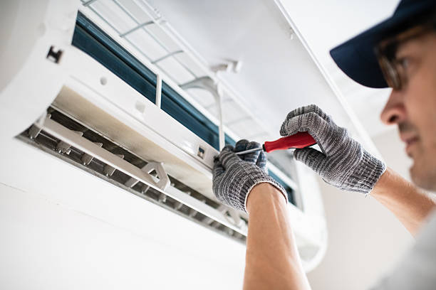 Experienced HVAC technician testing AC system performance with diagnostic tools indoors, HVAC technician checking refrigerant readings and airflow during detailed AC diagnosis