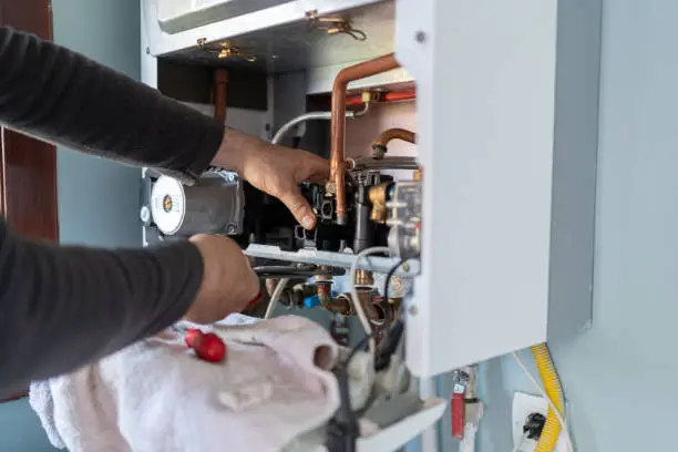 Heater Repair in Macungie - PA as a technician tests furnace airflow near a hallway vent