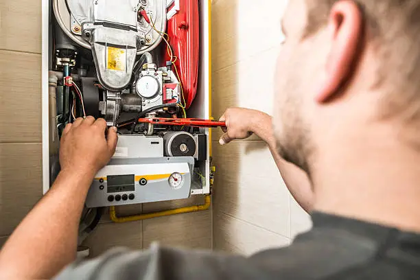 Technician performing Heater Repair on a furnace in a Macungie - PA basement during winter