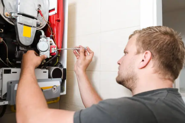Heater Repair in Easton - PA as a technician tests furnace wiring in a basement